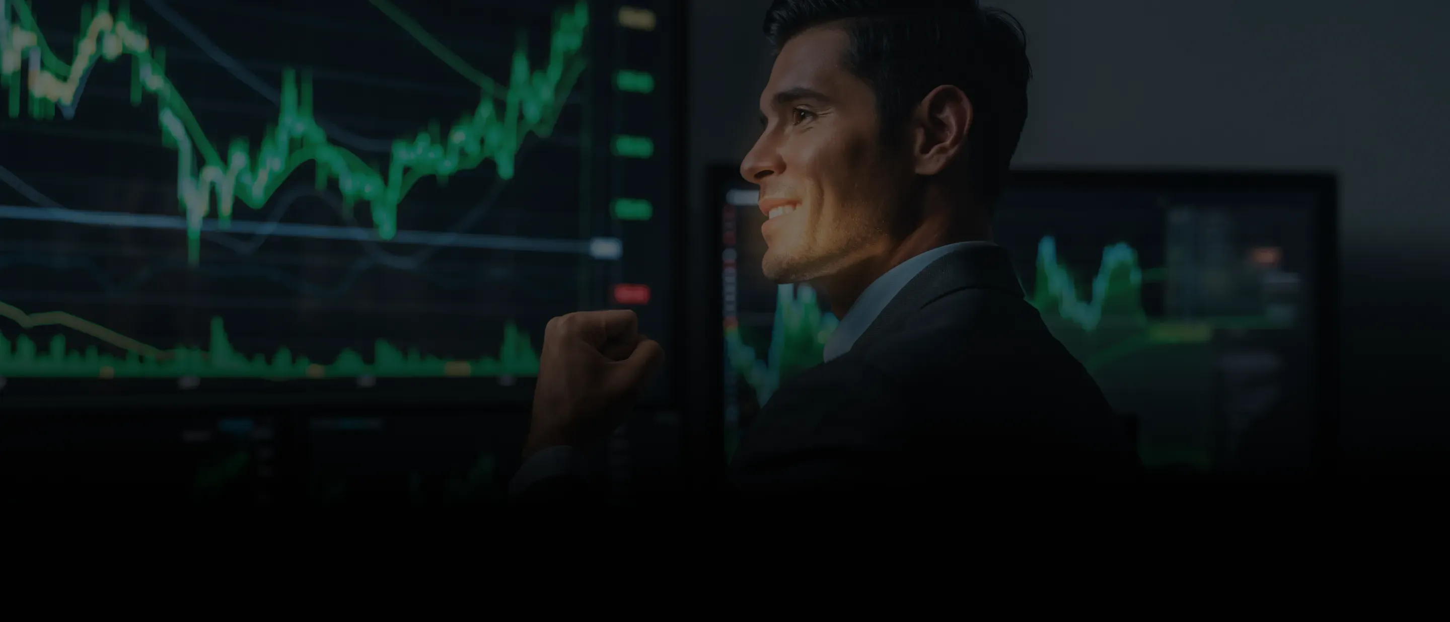 Homem sorrindo em frente à telas com gráficos de trading